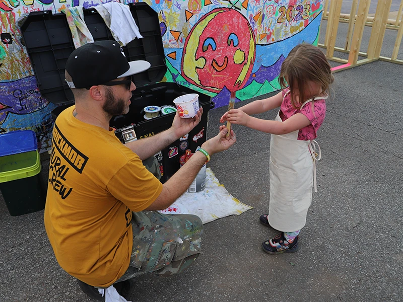 Brickmob staff helping children learn how to paint.