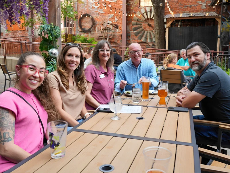 Habitat team members gathered around at a table and smiling.