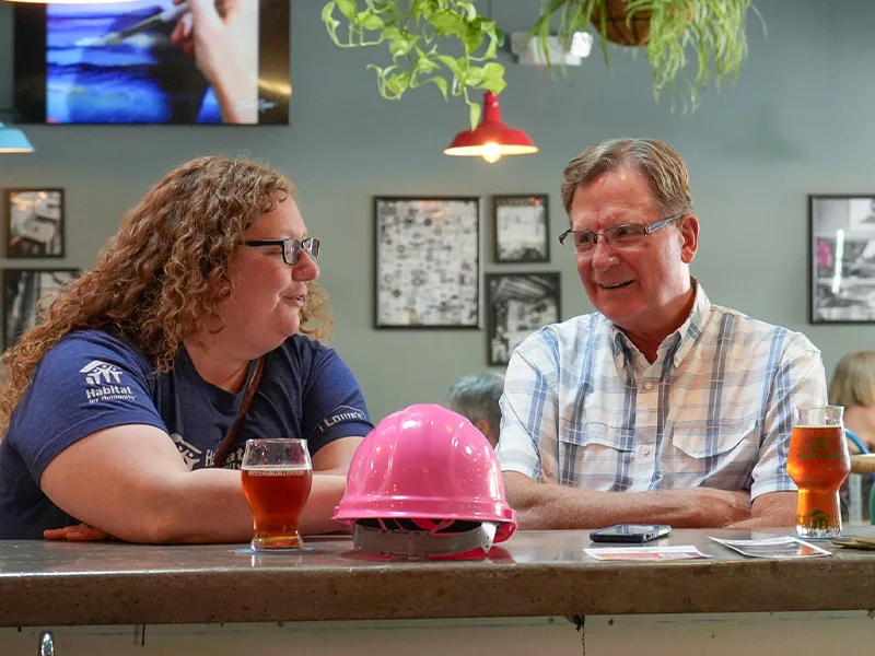Two people talking to each other at the bar counter.
