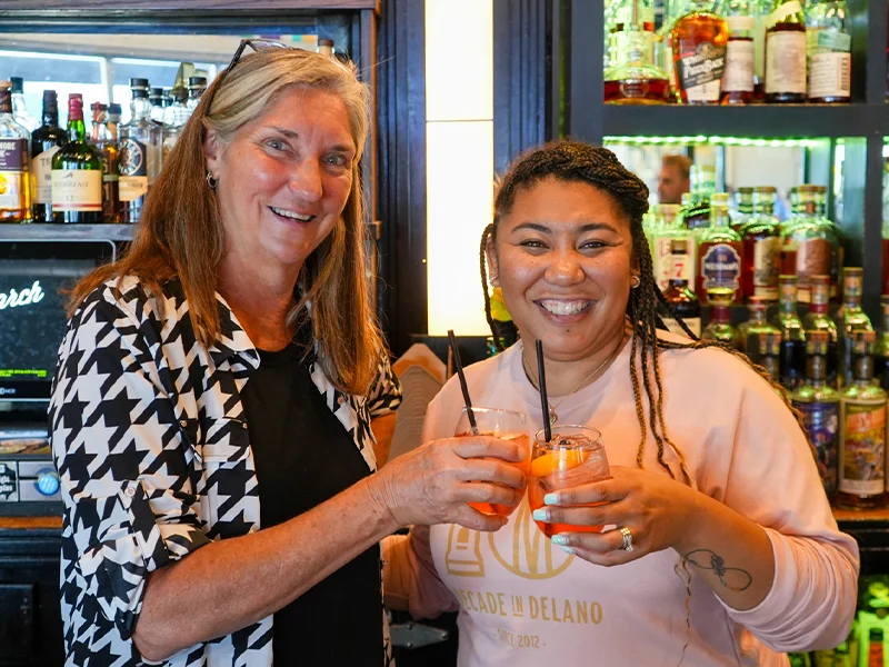 Danielle Johnson and Ann Fox clinking their glasses together.