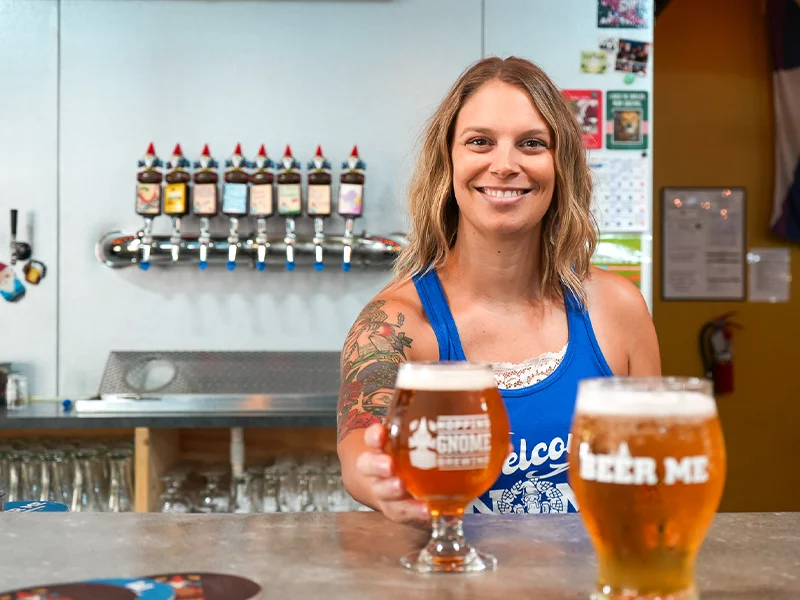 A bartender holding a glass of beer.