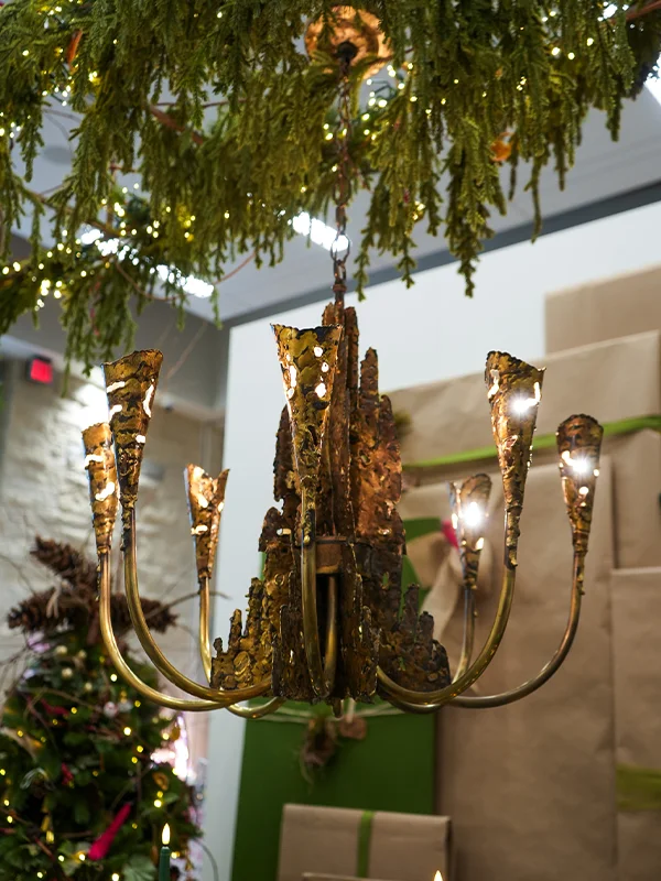 The torch cut Brutalist chandelier glowing.